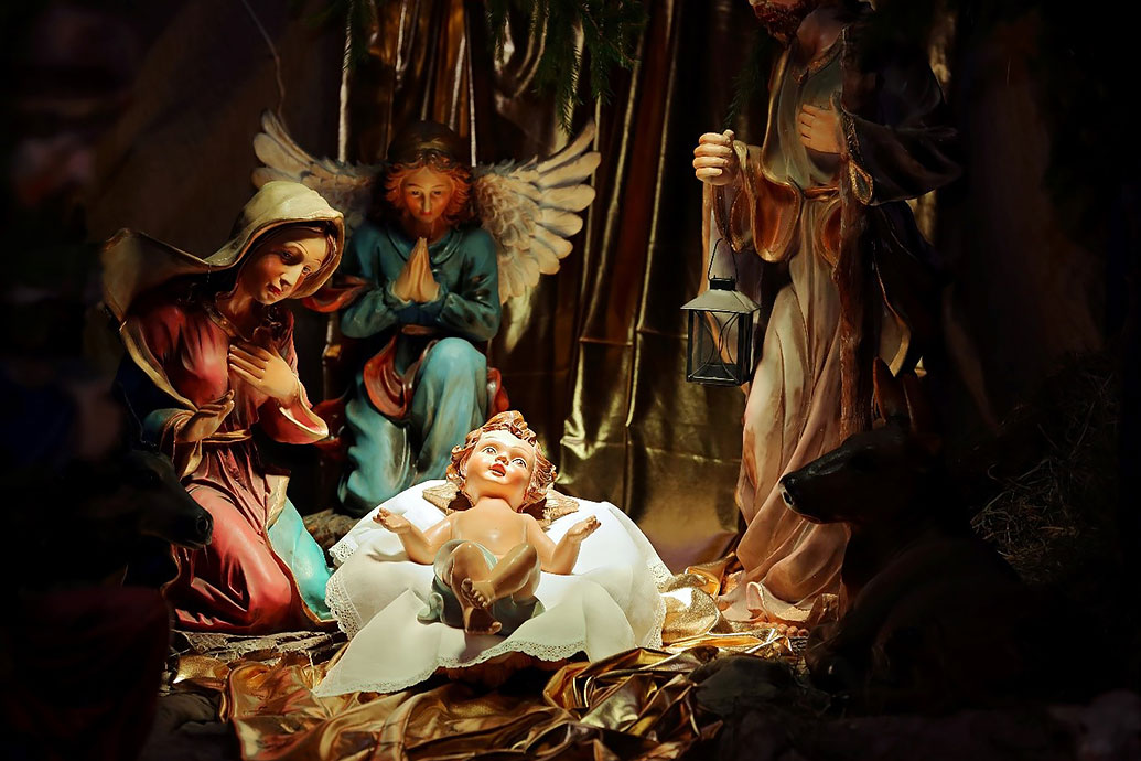 Das Christkind in der Krippe – daneben Maria und Josef