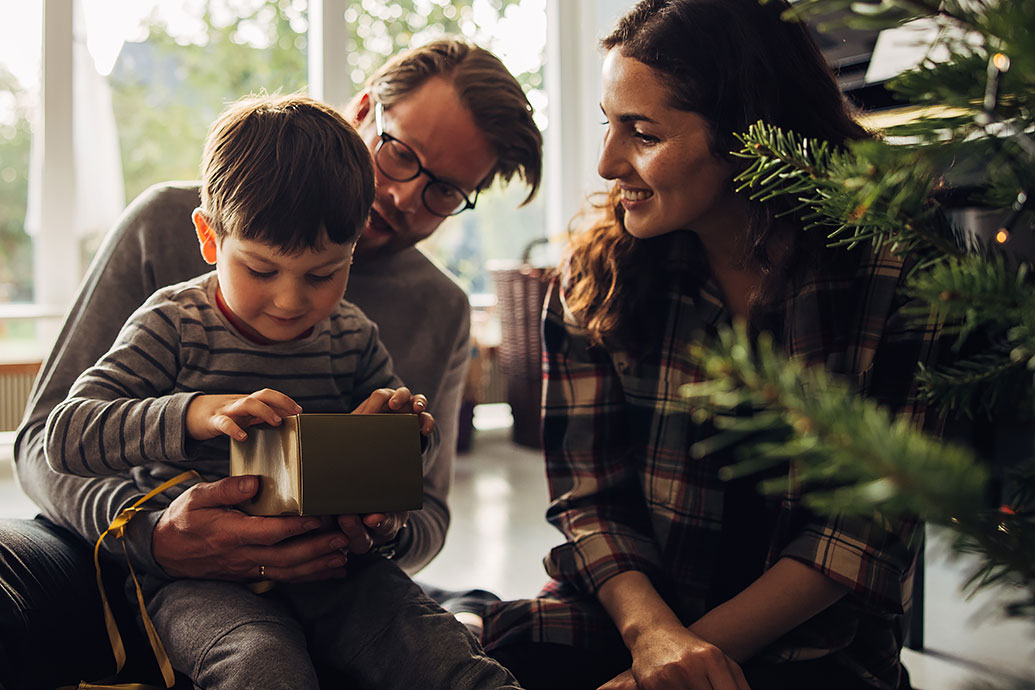 Il bambino riceve un regalo di Natale dai suoi genitori