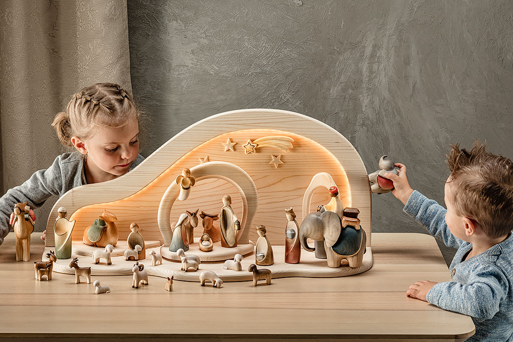 Two children are playing with the Fairy-Tale nativity scene