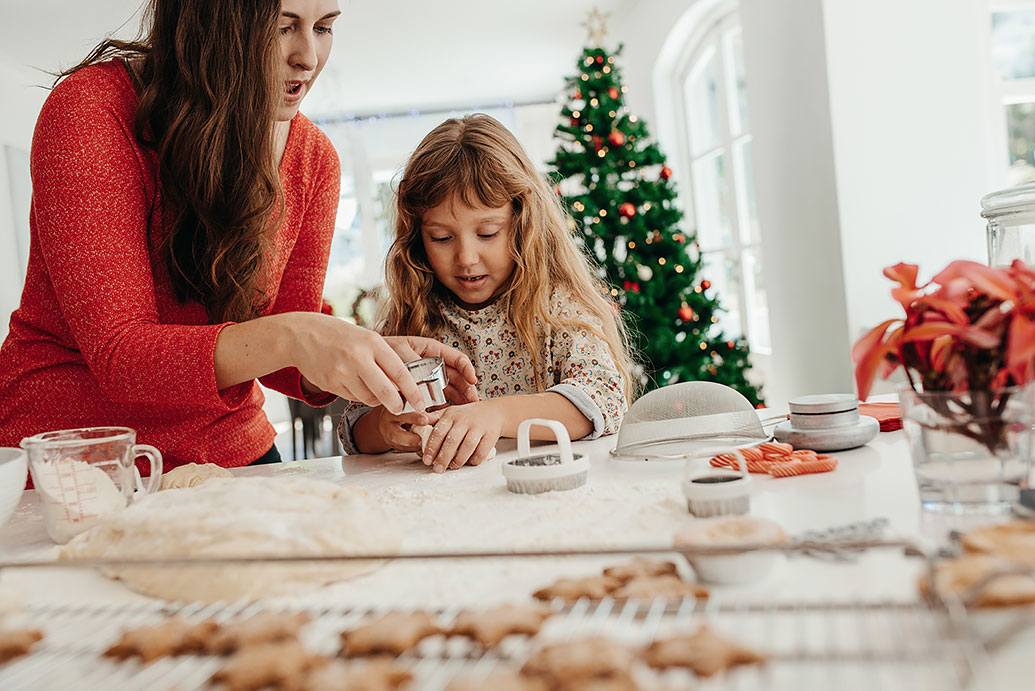 Mutter und Tochter backen gemeinsam Weihnachtskekse