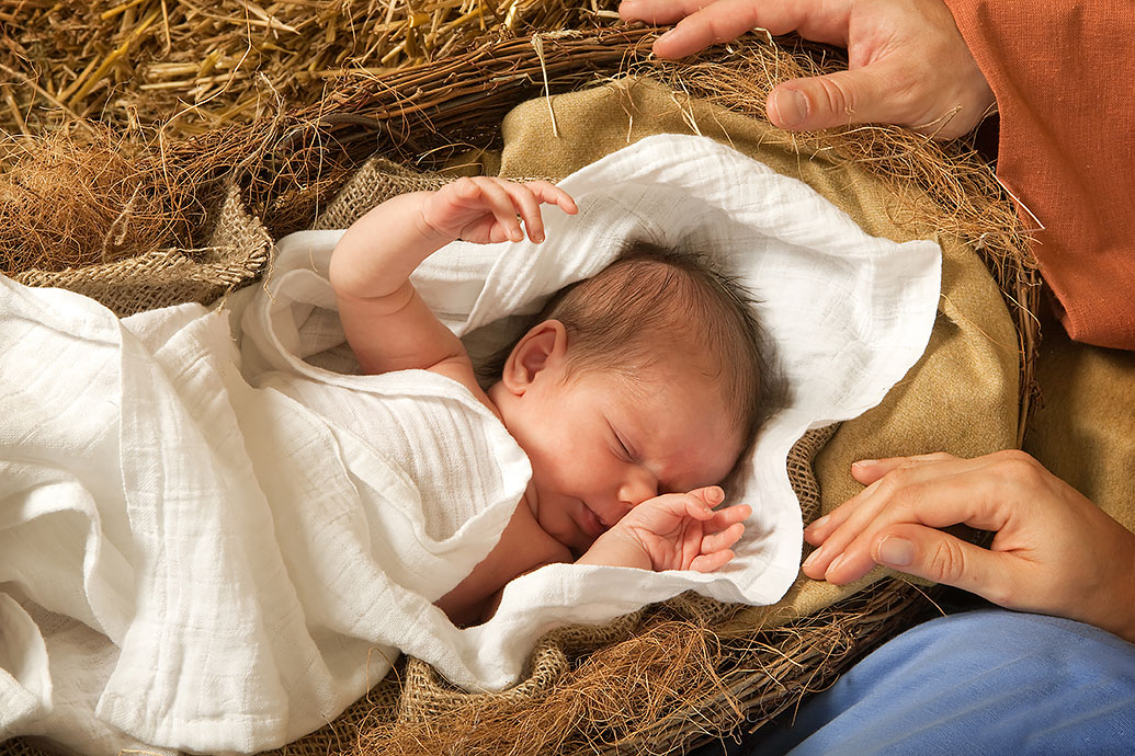 Baby Jesus lies in a straw bed