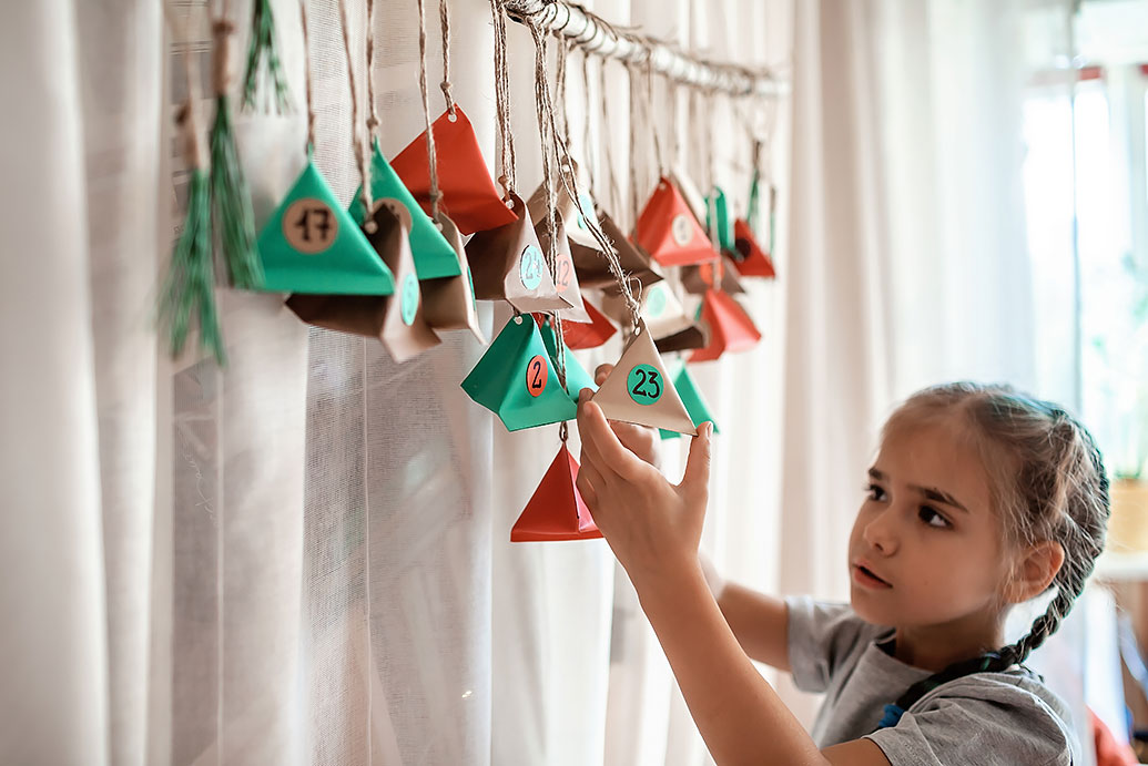 Mädchen betrachtet ihren Adventskalender