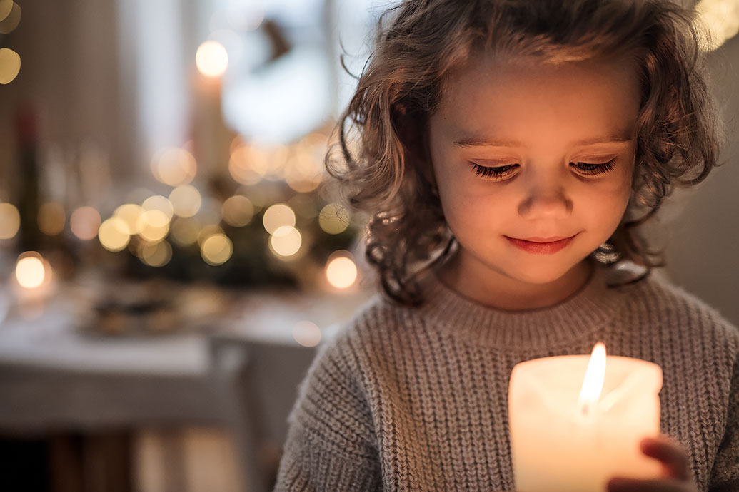 Il bambino tiene una candela nelle sue mani