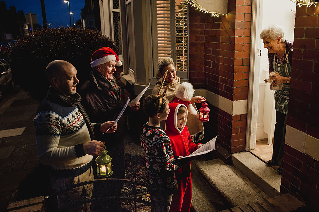 Le famiglie cantano una canzone al vicino a Natale