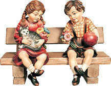 Bub und Mädchen sitzend auf Bank